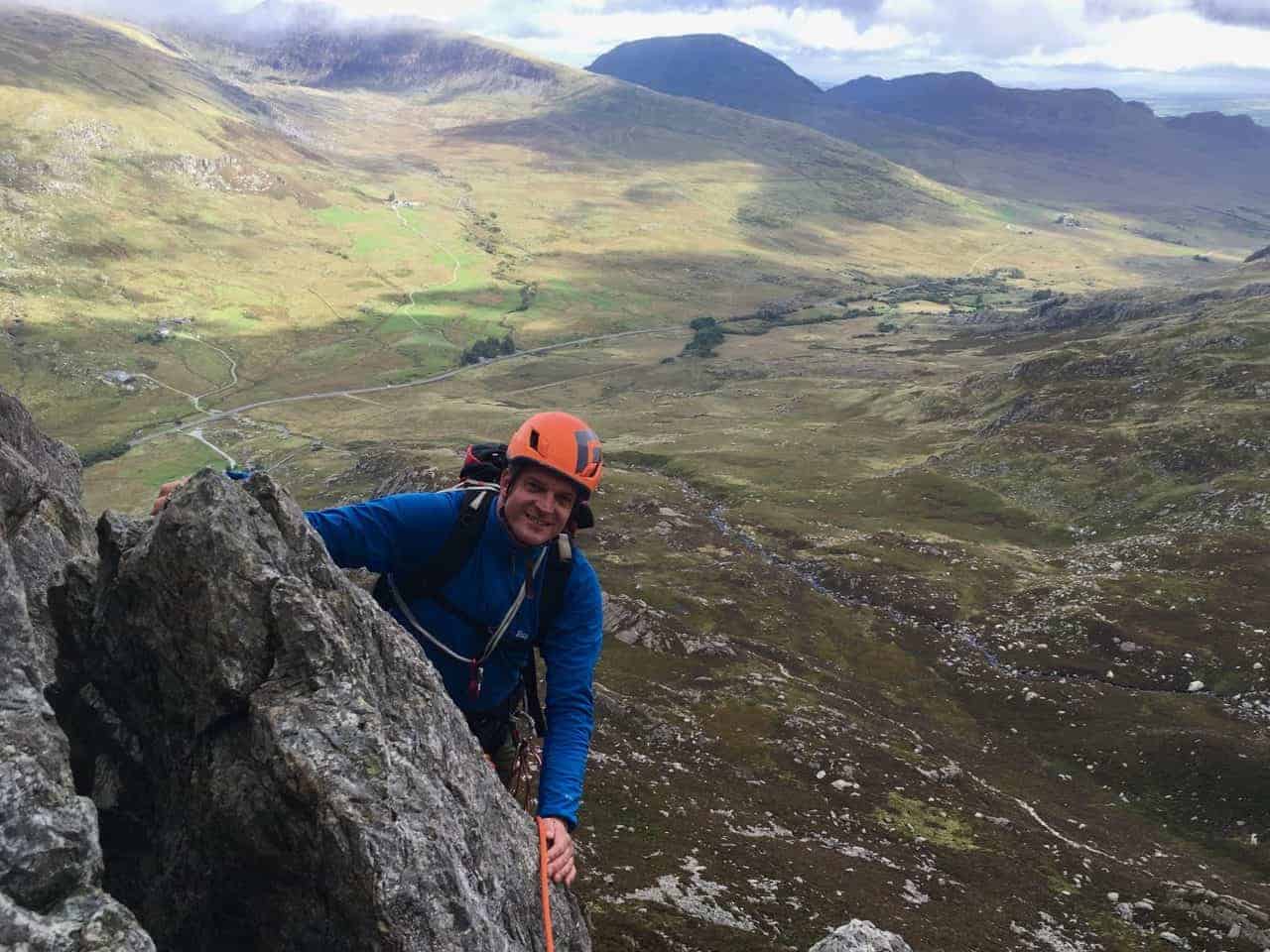 A man scrambling on the East face of Tryfan in Snowdonia.