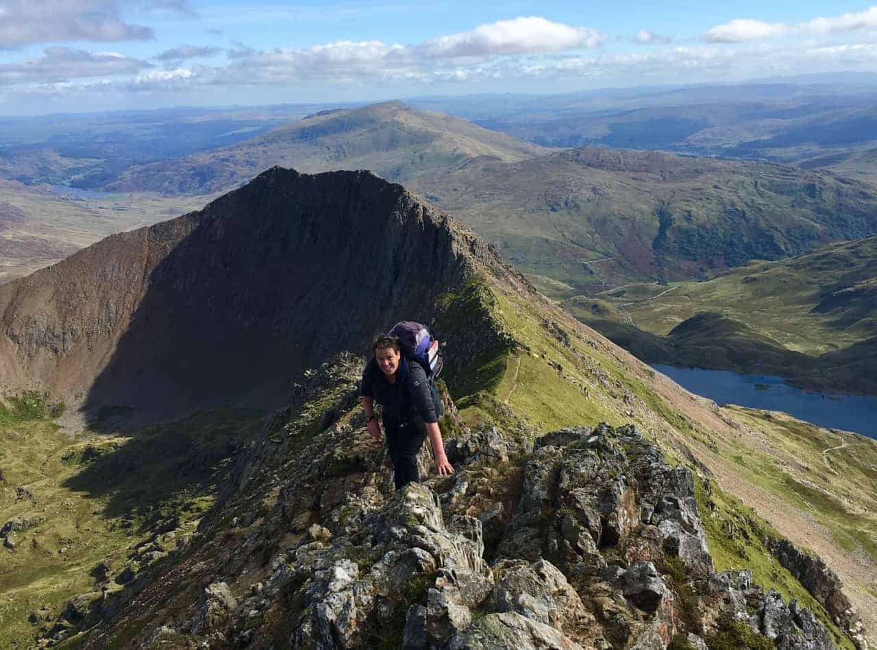 A lady scrambling along the upper slopes of Crib Coch after completing the classic Grade 1 scramble.