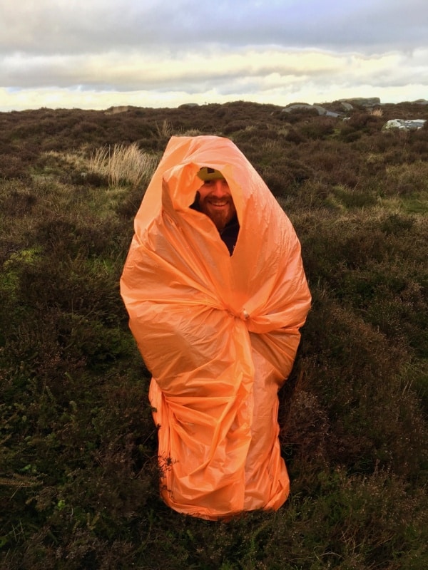 A man practices using a survival bag on a Mountain Leader course.