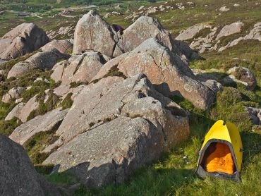 A lone yellow tent on an Mountain Training qualification Expedition Skills course