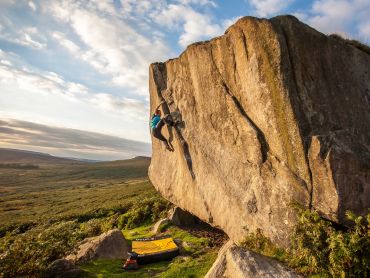 A man bouldering at Stanage in the Peak District