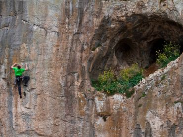 A man learning to lead a sport climb on a course in the Peak District national park