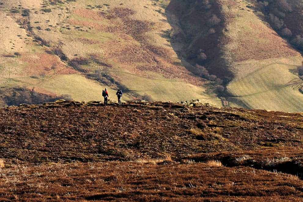 Two people walking on the hills around Edale on a Hill and Moorland Leader course