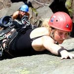A young lady learning to lead on a Peak District rock climbing course