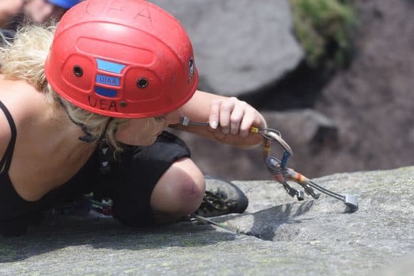 A girl learning to lead climb on Stanage edge in the Peak District