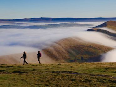 Hillwalking in the Peak District. Two walkers descend off Mam Tor heading to Lose hill.