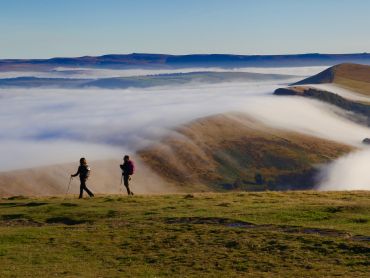 Two ladies stand on Mam Tor in the Peak District whilst on a guided walking holiday.