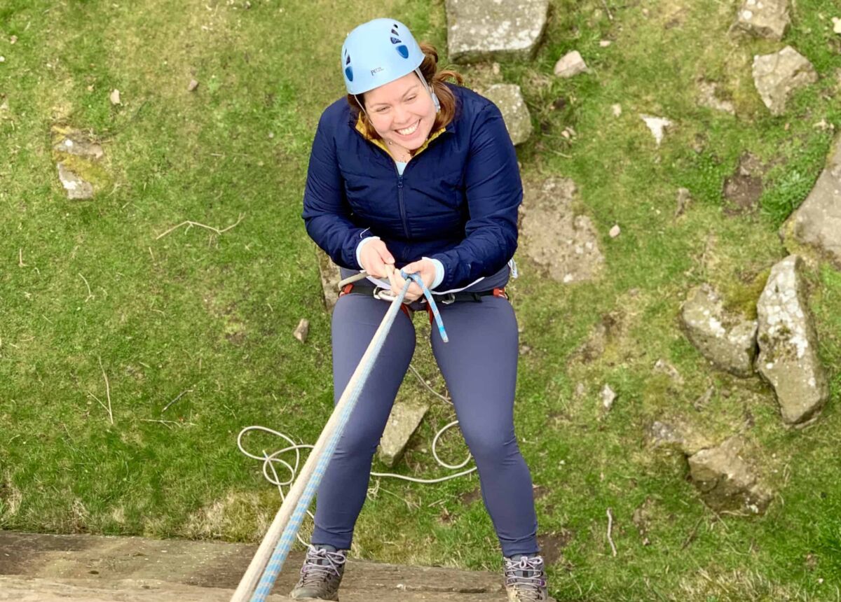 A lady abseiling on a Peak District abseil challenge event.