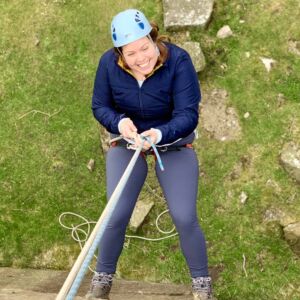 A lady abseiling on a Peak District challenge event.