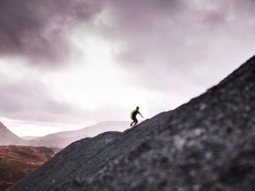 A man runs up a hill on a fell running course in the Peak District