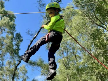 A child on a zip line on a family adventure day in the Peak District