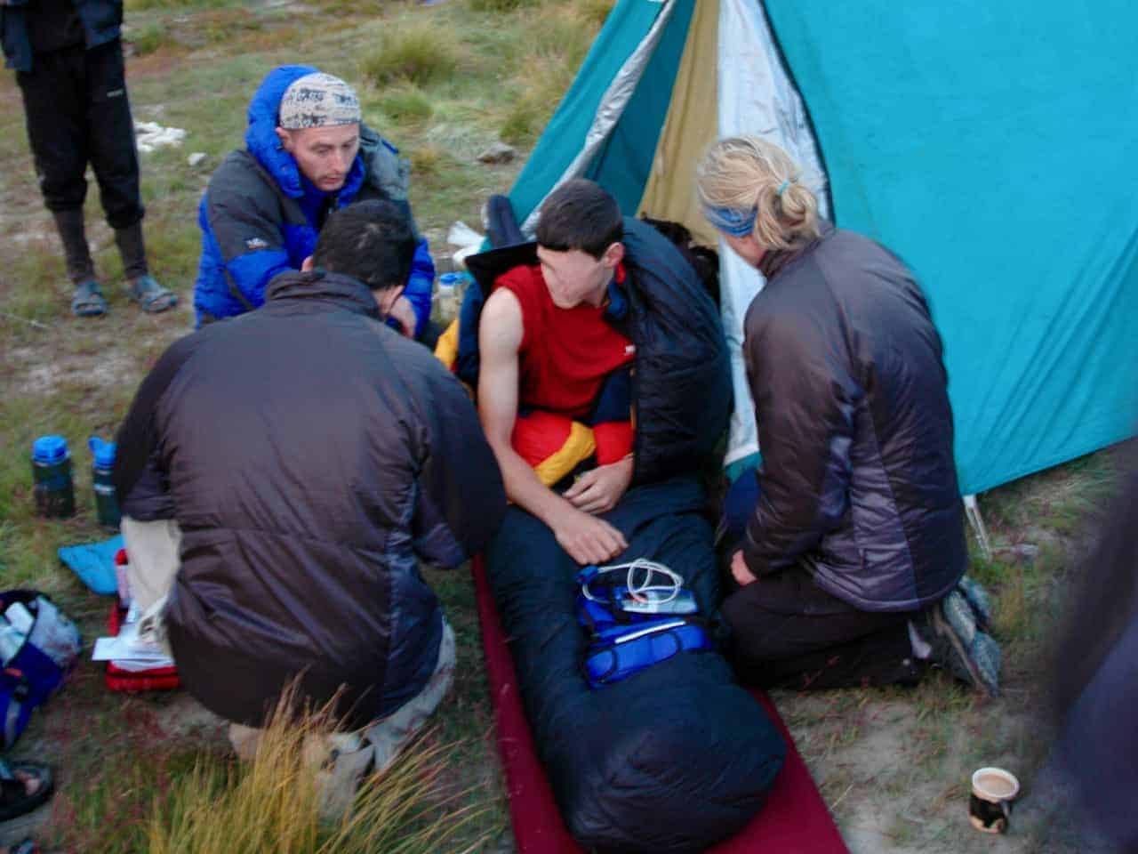 An expedition group gives first aid to a casualty after being on a first aid course in the Peak District