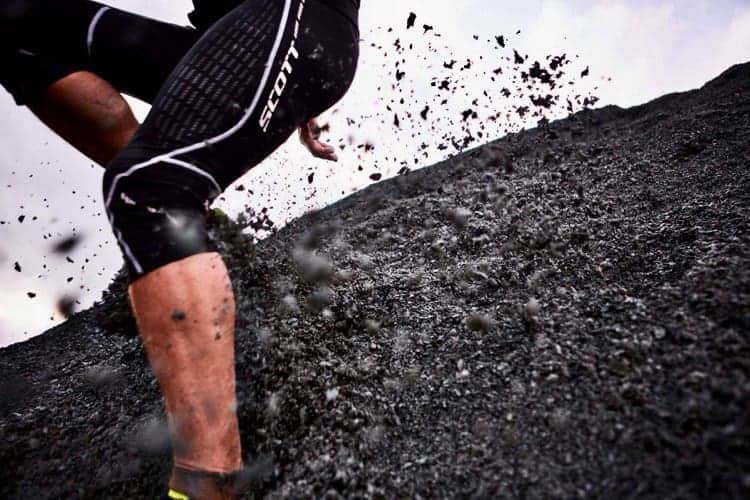 A trail runner runs down steep ground on a running course in the Peak District