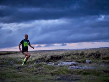 A man runs along a trail on a trail running course in the Peak District