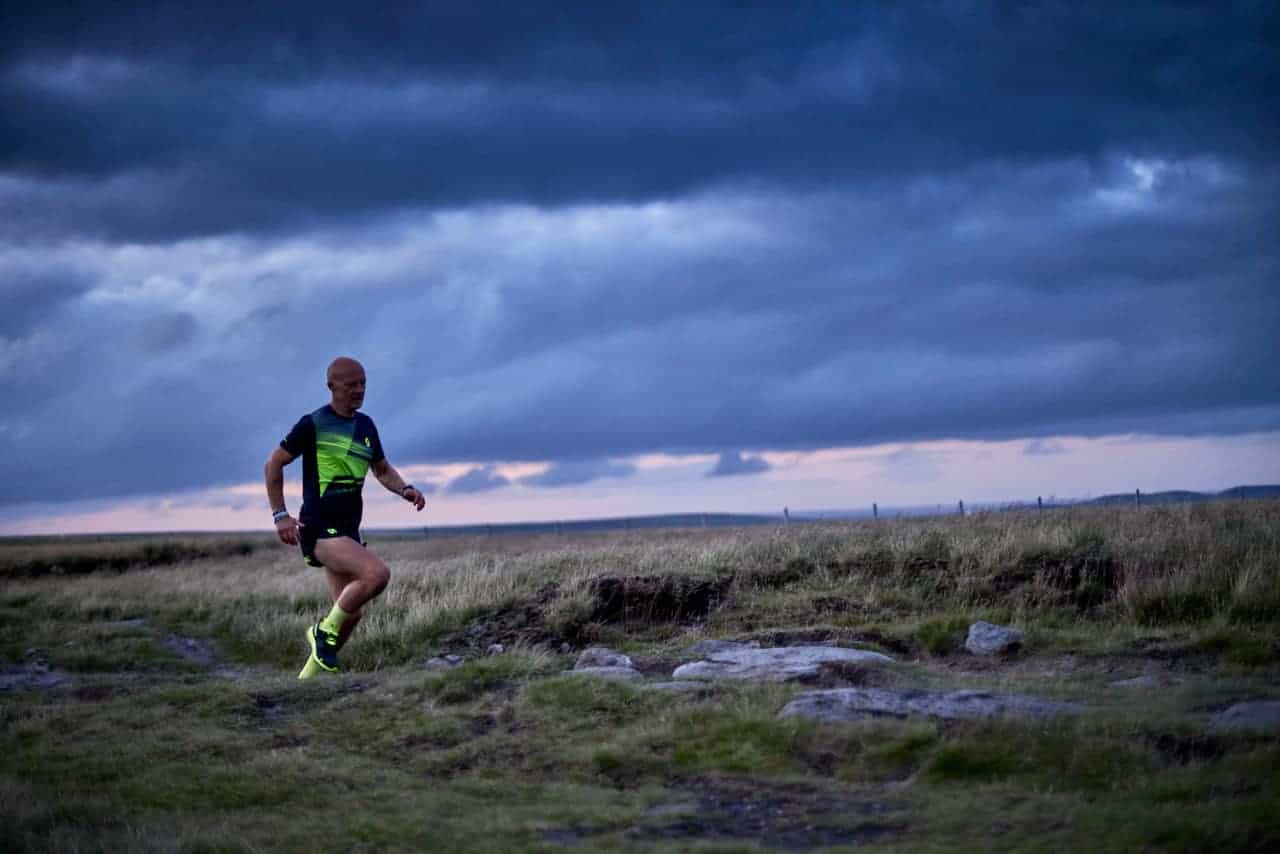 A man runs along a trail on a trail running course in the Peak District