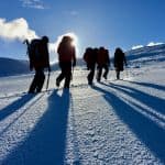 A group walking on snow on a winter skills course in Scotland