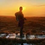 A lady watches the sunset from a footpath in the Peak District