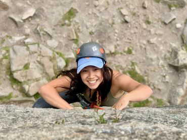 A young lady rock climbing on Burbage Edge whilst on a rock climbing course.