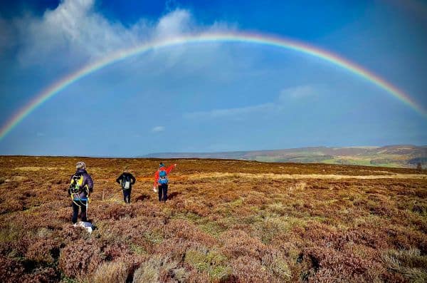 Hill walkers admire a rainbow whilst on a Hillwalking course in the Peak District