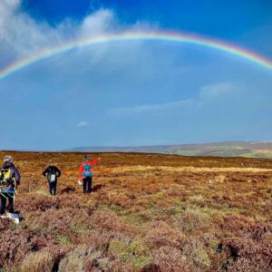 Hill walkers admire a rainbow whilst on a Hill Skills course in the Peak District