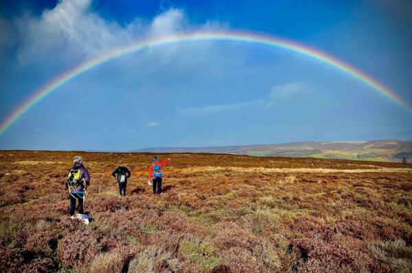 Hill walkers admire a rainbow whilst on a Hill Skills course in the Peak District