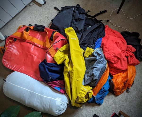 Pile of clothes and a Mountain Equipnment Duffle bag in preparation for OMM 2023