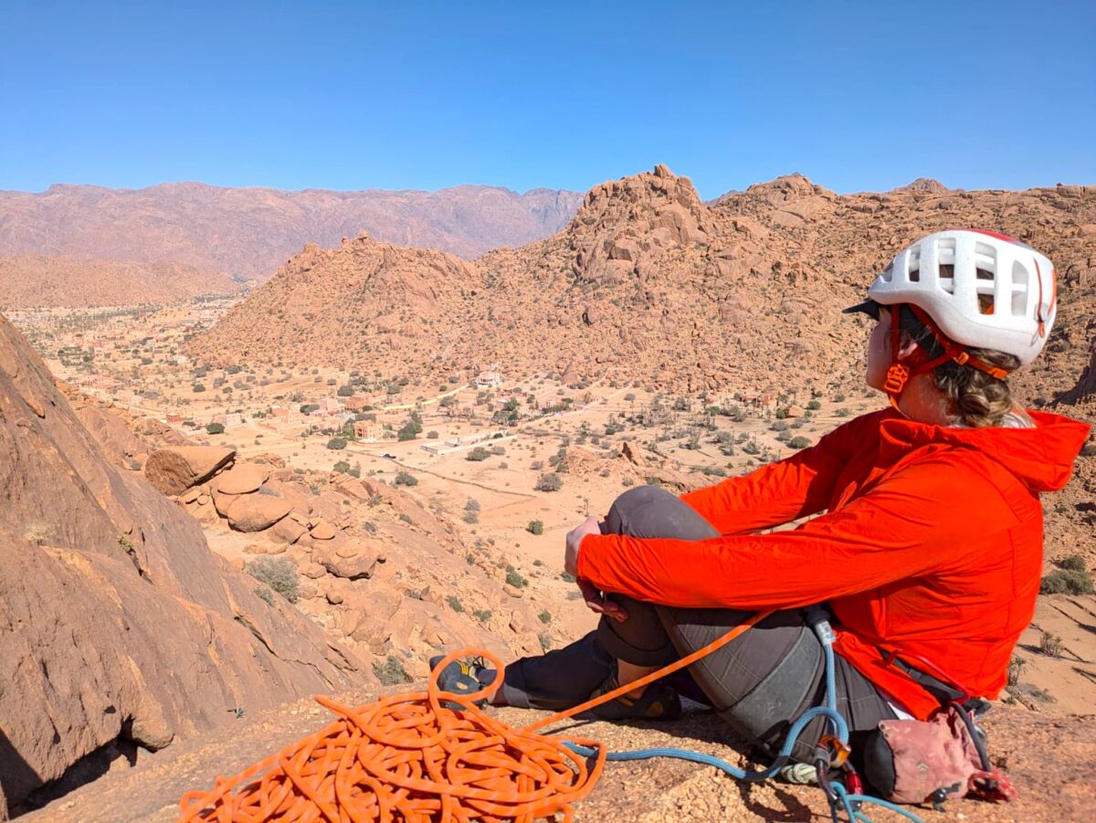 A female in a red top Climber resting on rocky outcrop in Morocco