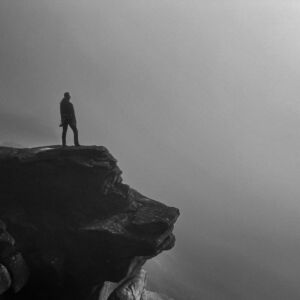 A lady overcoming her fear of heights, looking over Stanage Edge in the mist