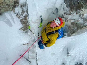 A winter climber, with ice axes in Scotland.