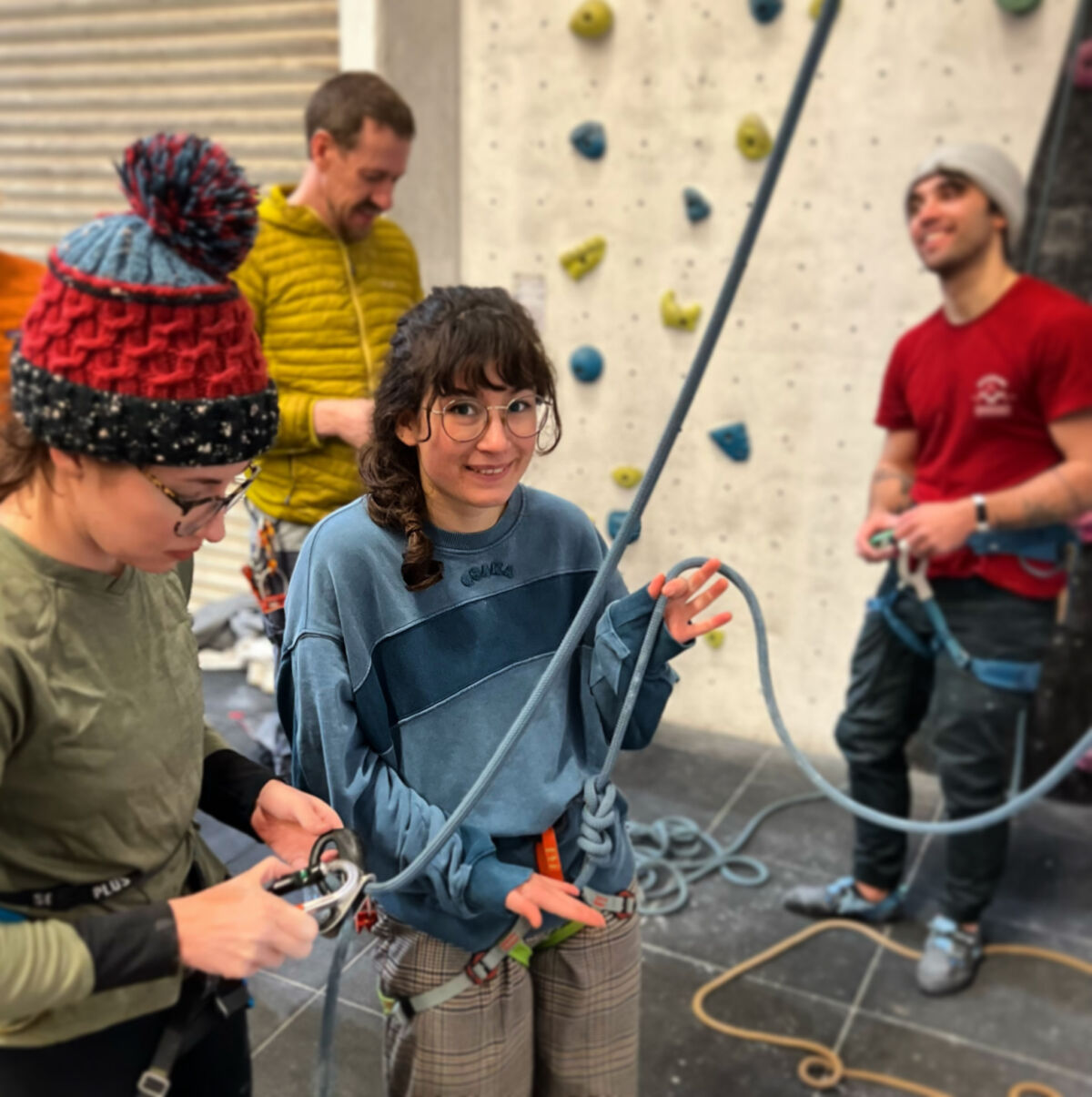 Two women learning to supervise climbing on a climbing wall instructor course.