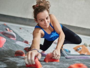 A woman instructing bouldering in a bouldering gym
