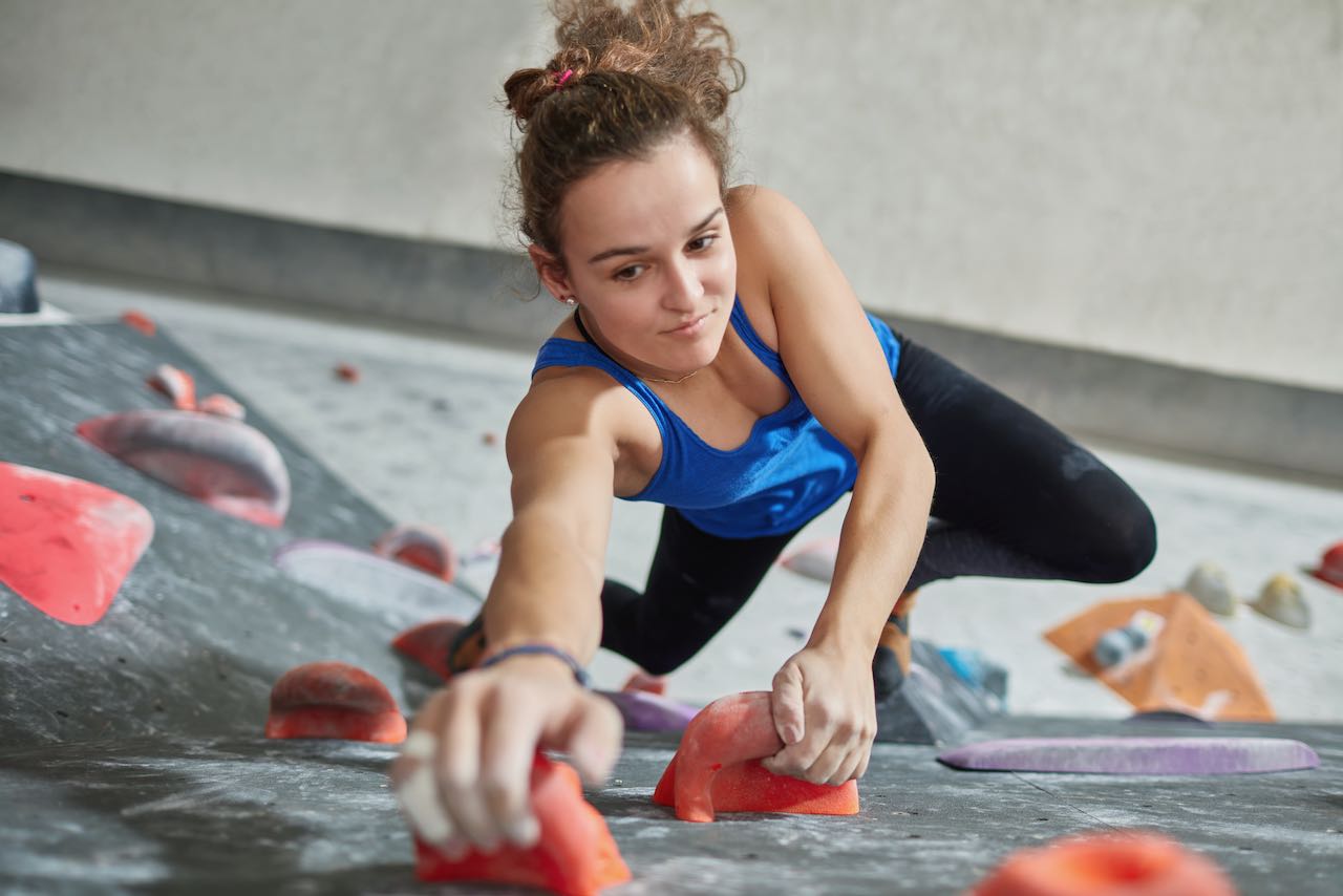 A woman instructing bouldering in a bouldering gym