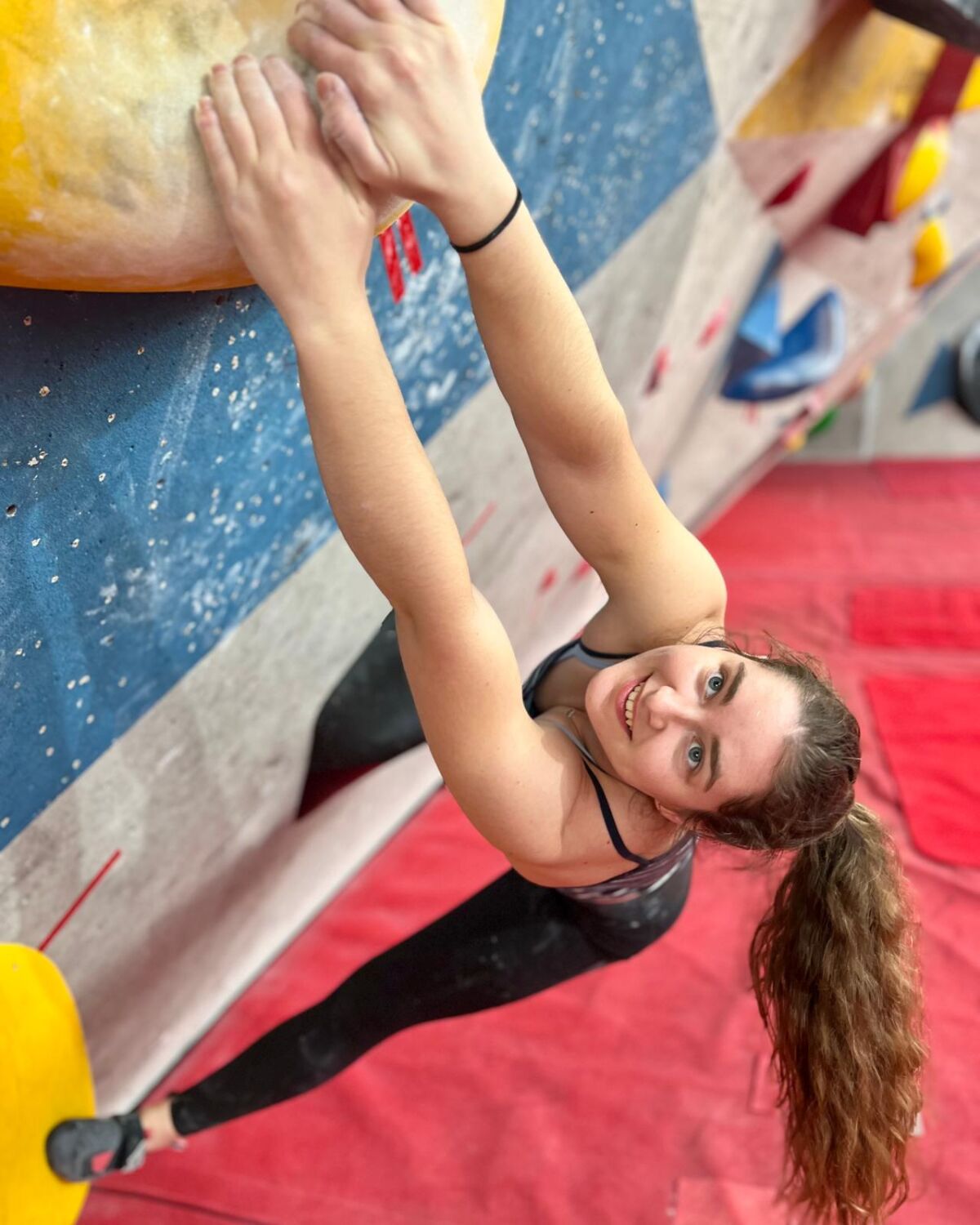woman climbing in a bouldering wall matching a hold