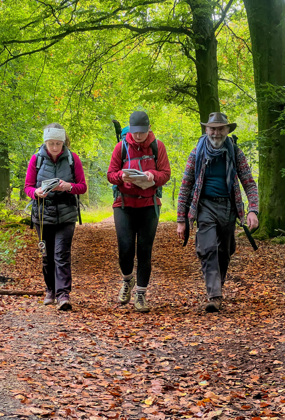 Three people walk down a path on Chatsworth estate on a Lowland Leader course.