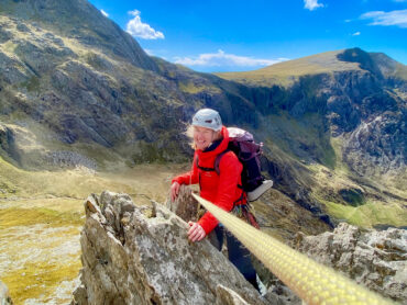 A woman scrambling on Cneifon arete on a scrambling course.