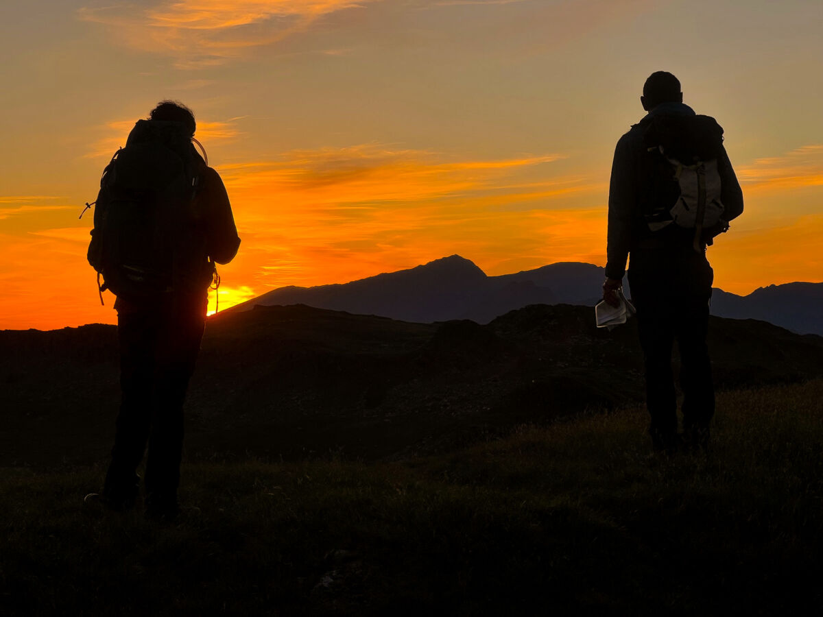 Two men look at their maps at sunset on a Mountain Leader assessment in the Moelwyns.