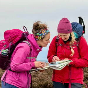 Two female hill walkers map reading on NNAS Gold course