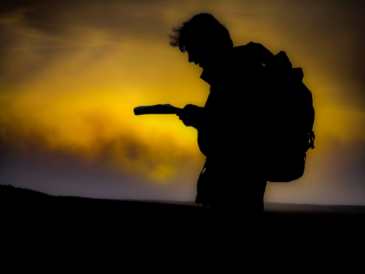 A man navigating in the setting sun in the Peak District.