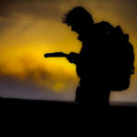 A man navigating in the setting sun in the Peak District.