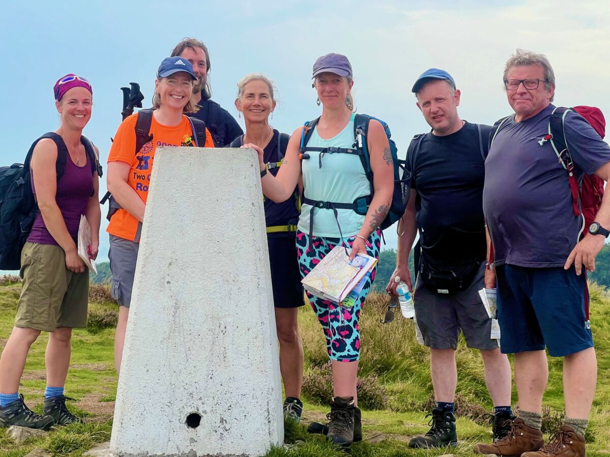 A group learning navigation on Kinder Scout in the Peak District.