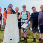 A group learning navigation on Kinder Scout in the Peak District.