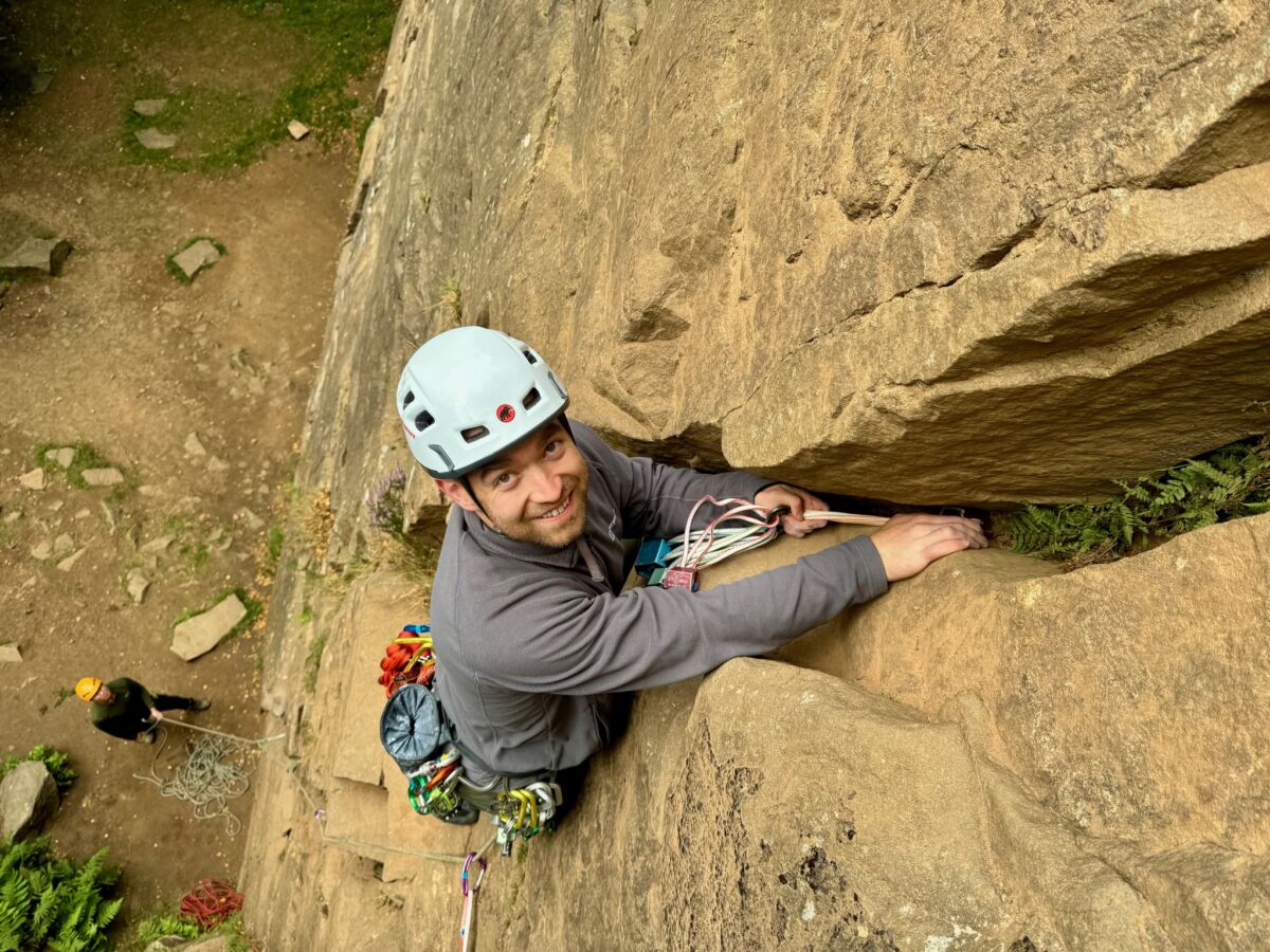 A man lead climbing on a rock climbing course in the peak District.