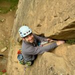 A man lead climbing on a rock climbing course in the peak District.