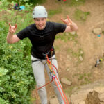 A man abseiling on an Introduction to rock climbing course in the Peak District.