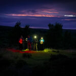 A group learning night navigation techniques on a Hill and Moorland Leader course in the Peak District.