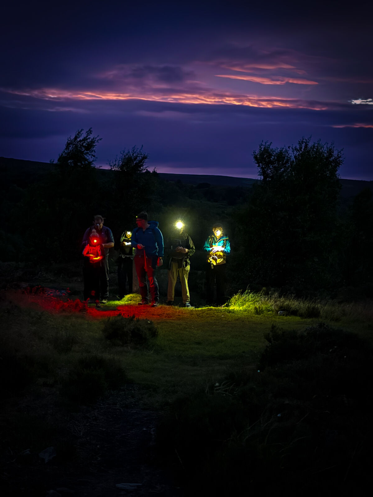 A group learning night navigation techniques on a Hill and Moorland Leader course in the Peak District.