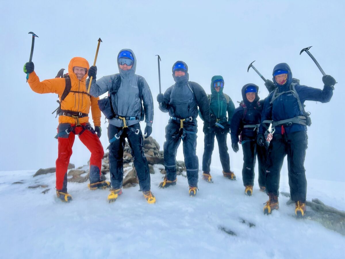 A group celebrate a successful summit whilst on a winter mountaineering course.