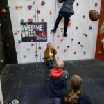 A group practicing bell ringing on a Climbing wall Instructor course.