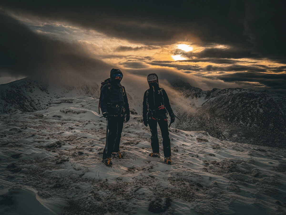 Two women with ice axes and crampons on Cairngorm on an Introduction to winter mountaineering course.