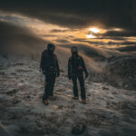 Two women with ice axes and crampons on Cairngorm on an Introduction to winter mountaineering course.
